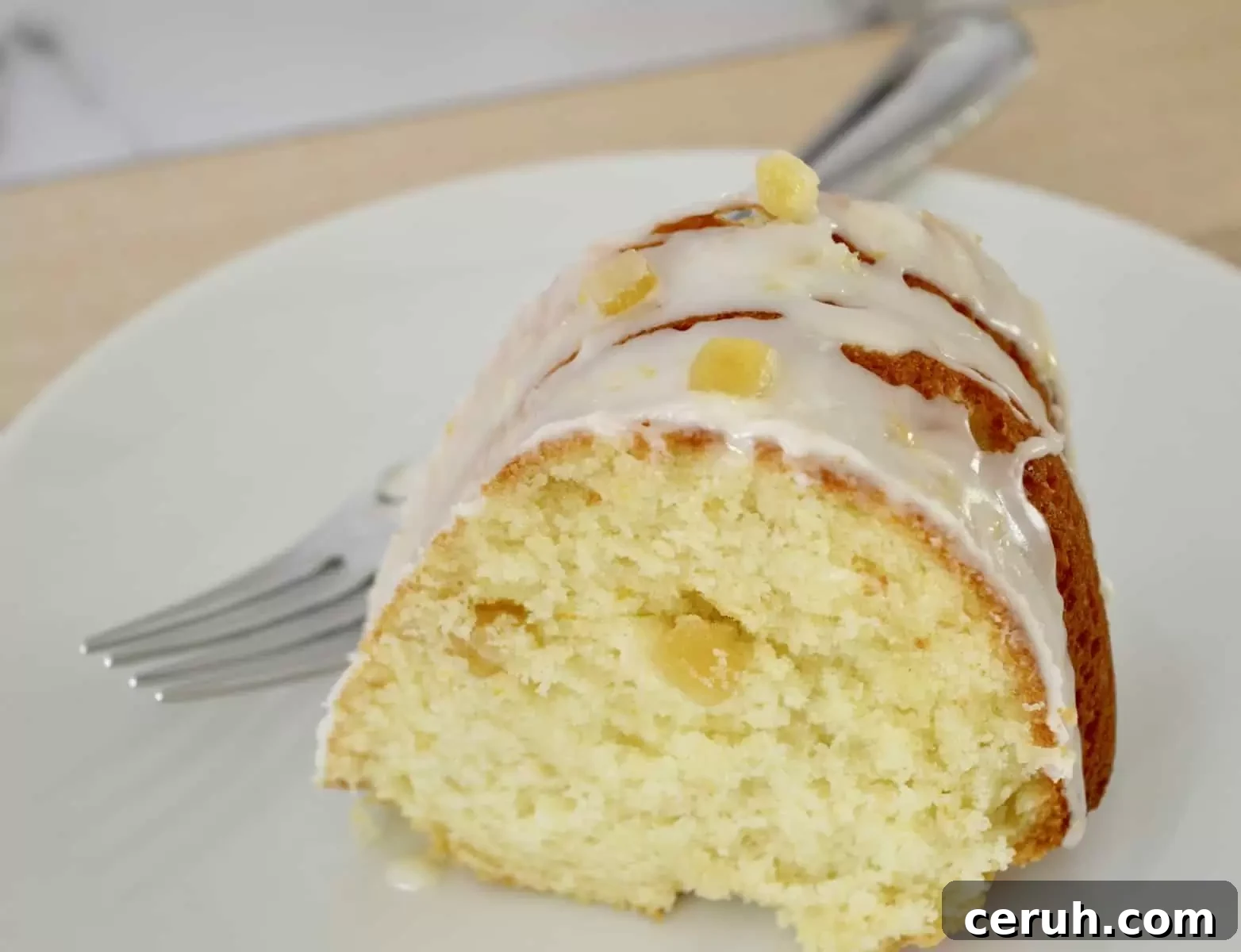 Slice of breakfast cake on a white plate with a fork next to it. 
