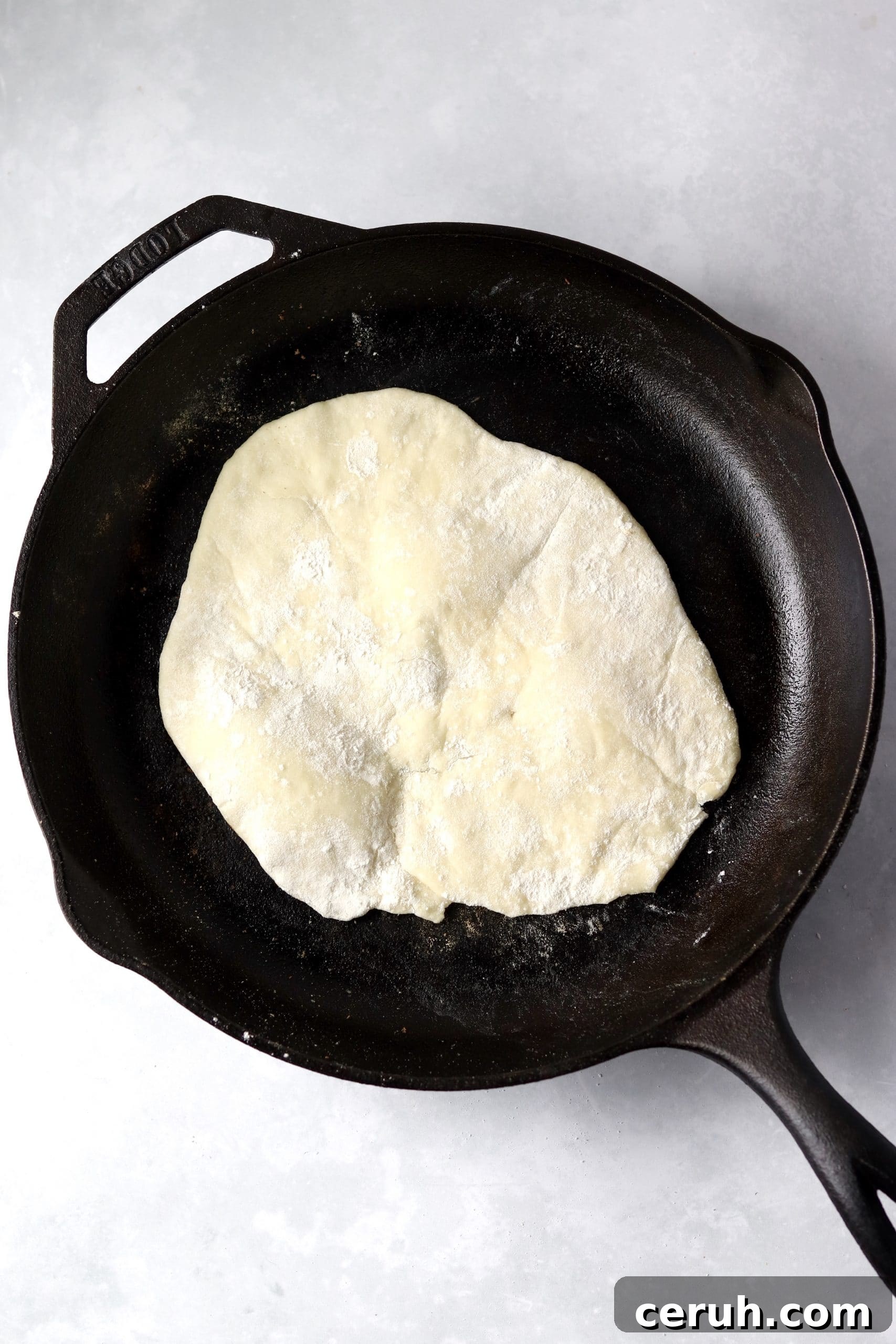 yogurt flatbread dough in hot skillet.