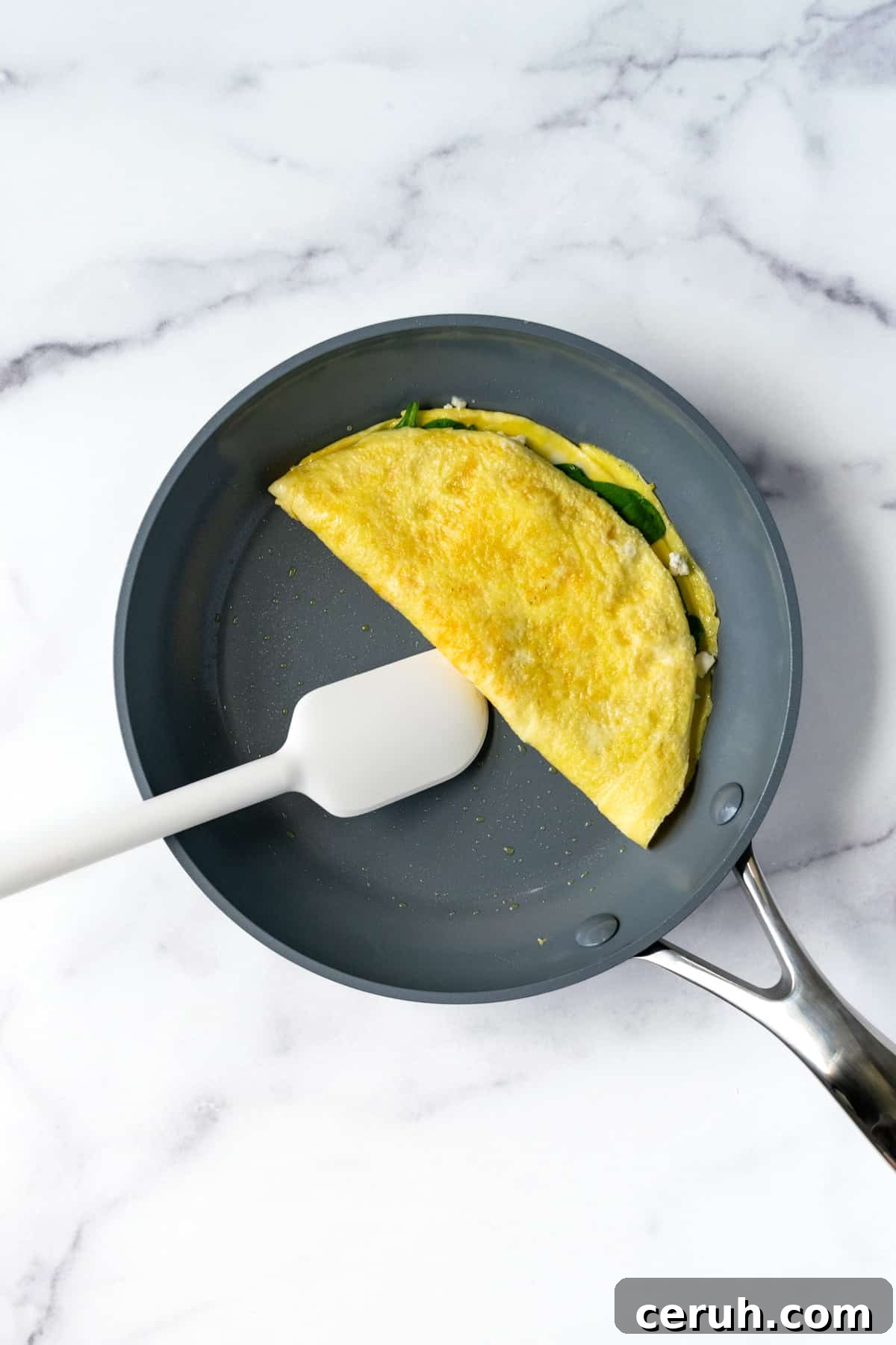 Spinach and Feta Omelette in non-stick pan.
