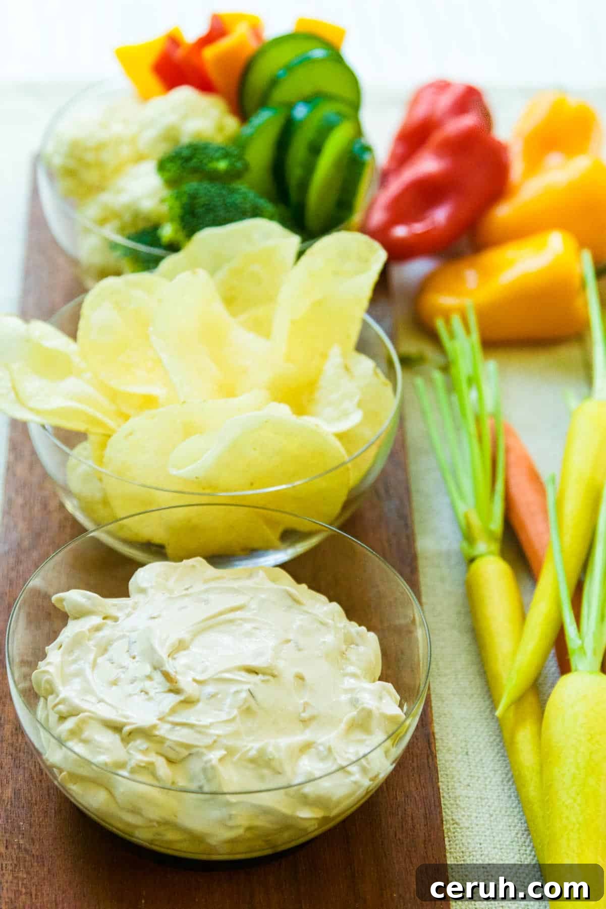 Bowl of onion dip with potato chips and veggies