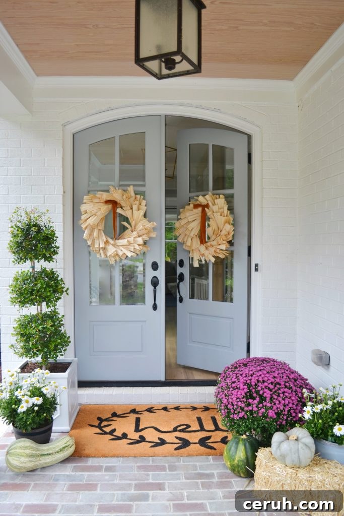 front door slightly open with large corn husk wreath hanging on the door