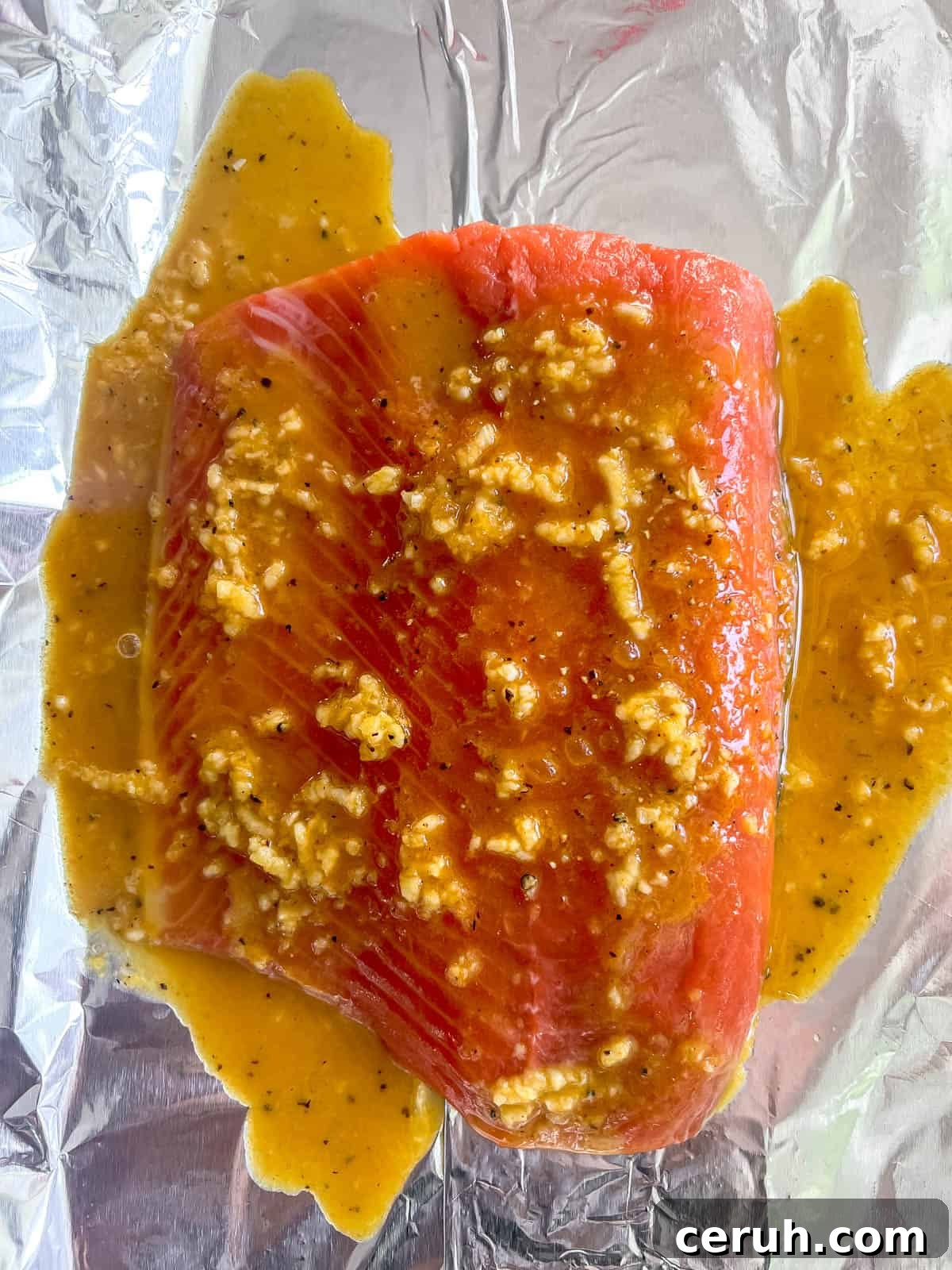 Salmon on foil with turmeric ginger sauce.