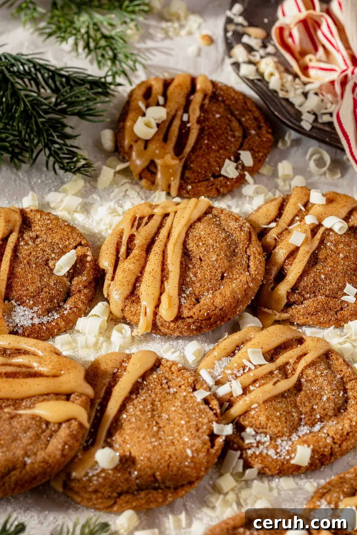 gingerbread latte cookies with brown butter glaze on a piece of parchment paper with a cup of coffee next to them.