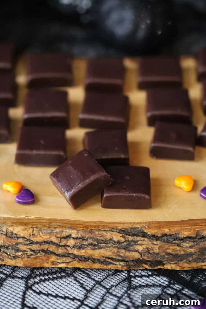 A serving platter full of squares of black licorice caramels.