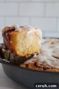 baked cinnamon roll lifted out of the pan