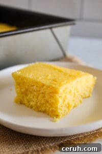 slice of gluten free cornbread on a white plate.