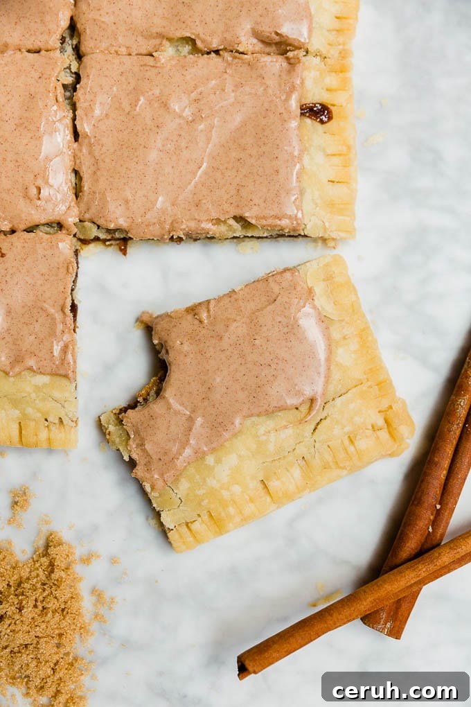 A giant pop tart with brown sugar cinnamon filling and cinnamon glaze with a bite out of a slice. 