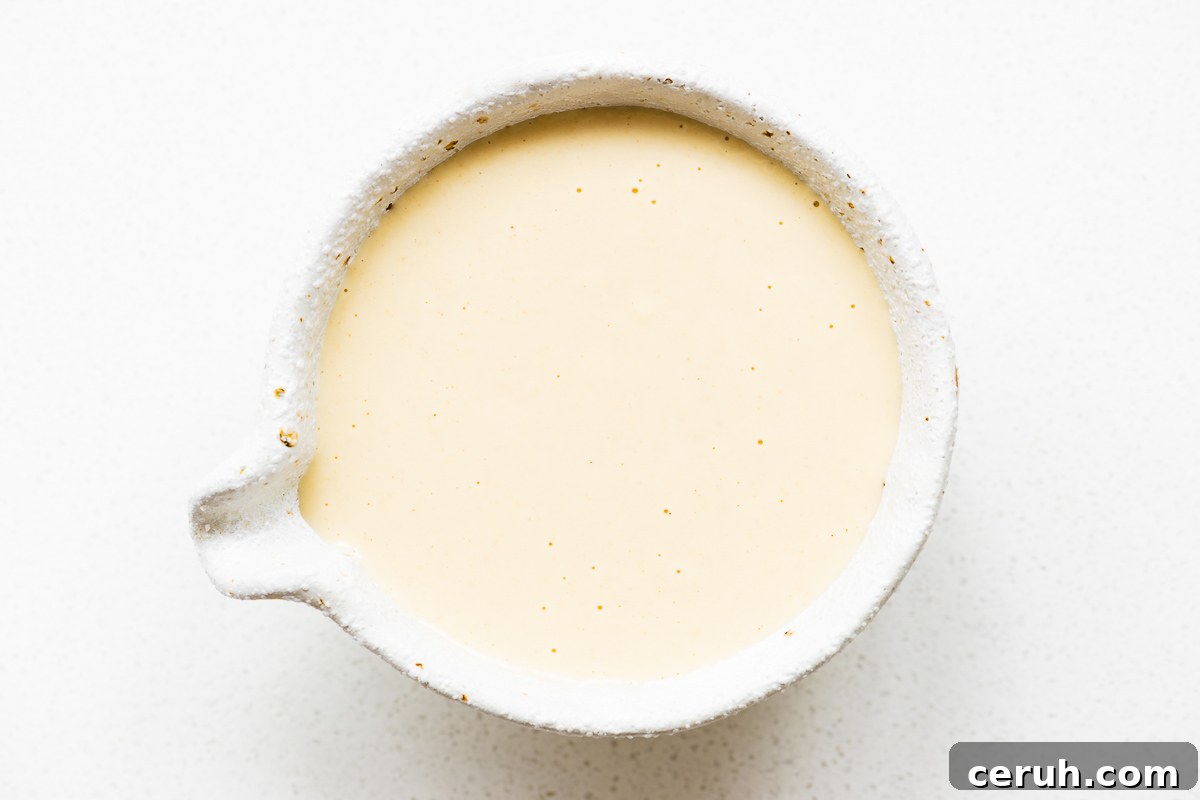 A small bowl with creamy tahini and maple salad dressing viewed from above.