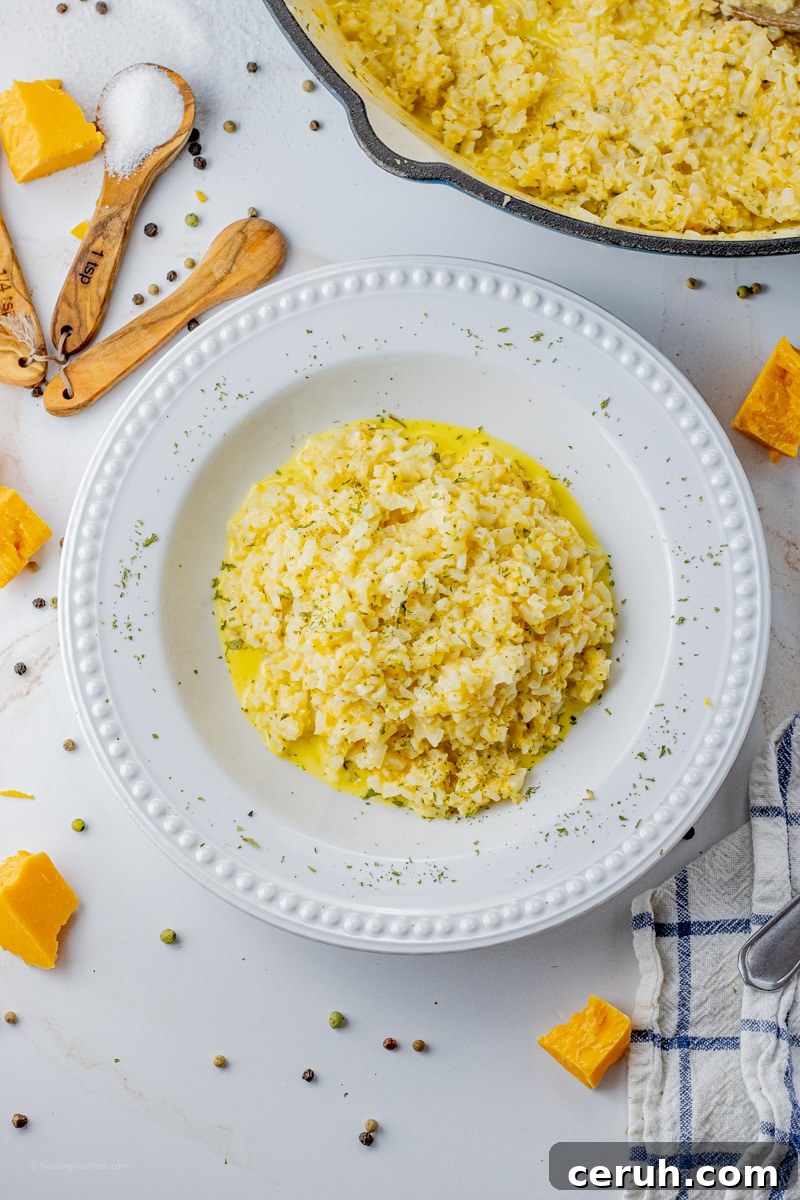 white bowl filled with cauliflower rice with cheese.