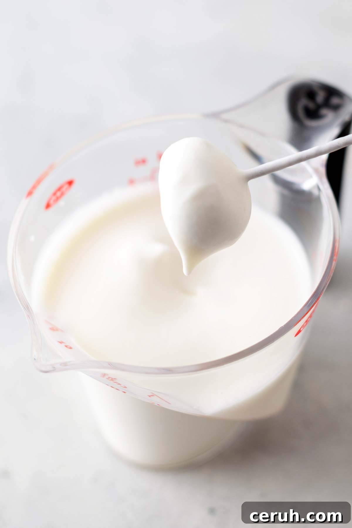 Whipped cream in a measuring cup.