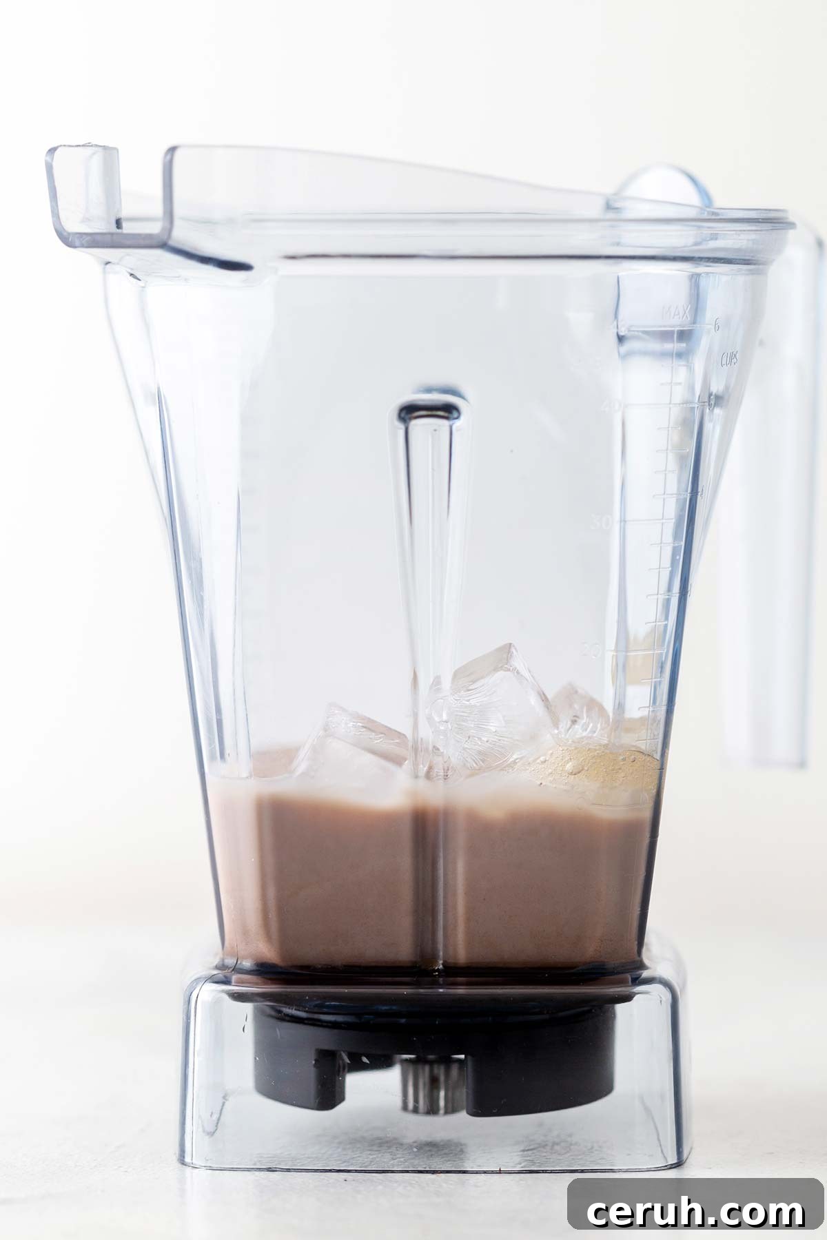 Chocolate sauce, dark chocolate bar, milk, ice, and homemade Frappuccino base syrup in a blender.