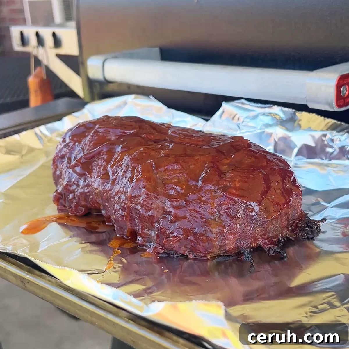The best smoked meatloaf recipe on a foil lined pan resting for 15 minutes.