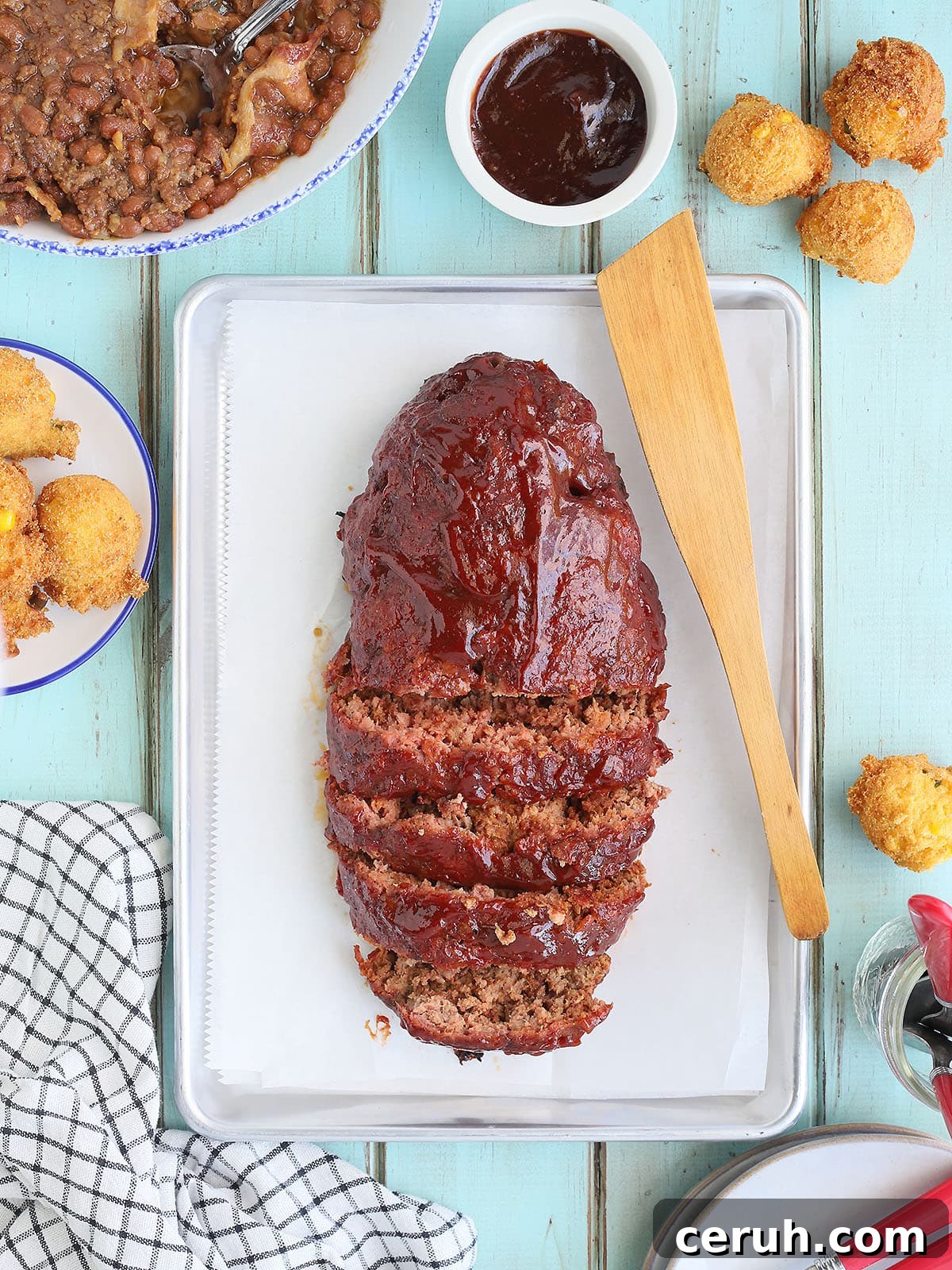 Sliced meatloaf on a parchment paper-lined tray.