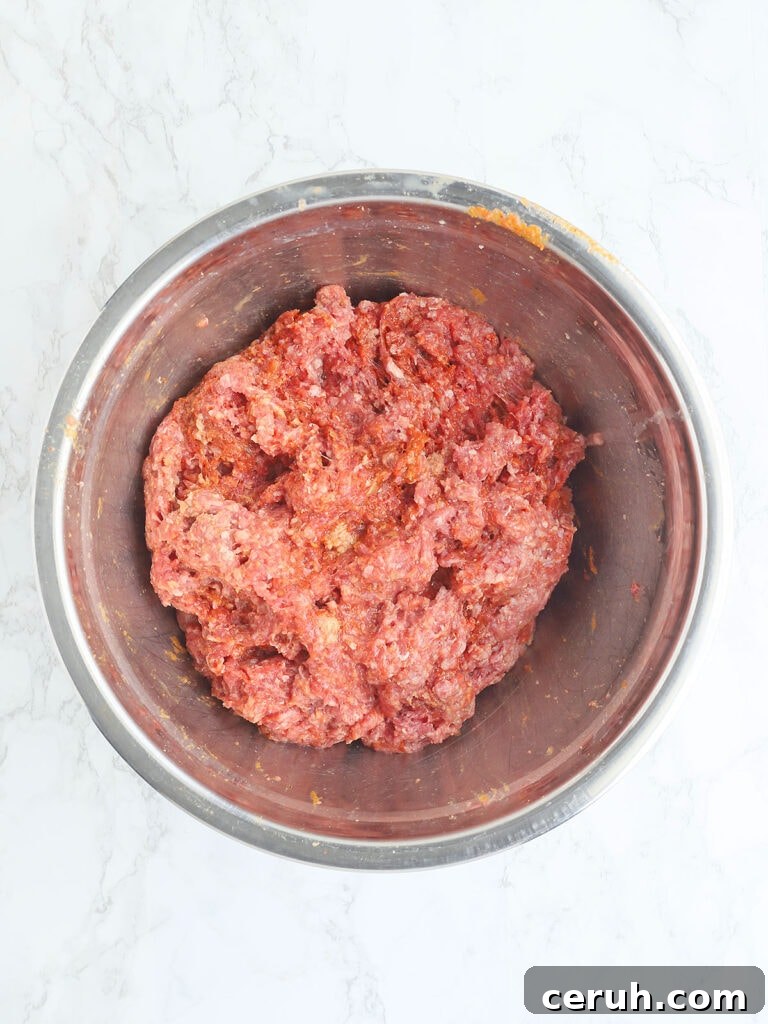 Meatloaf ingredients mixed together in a metal bowl.