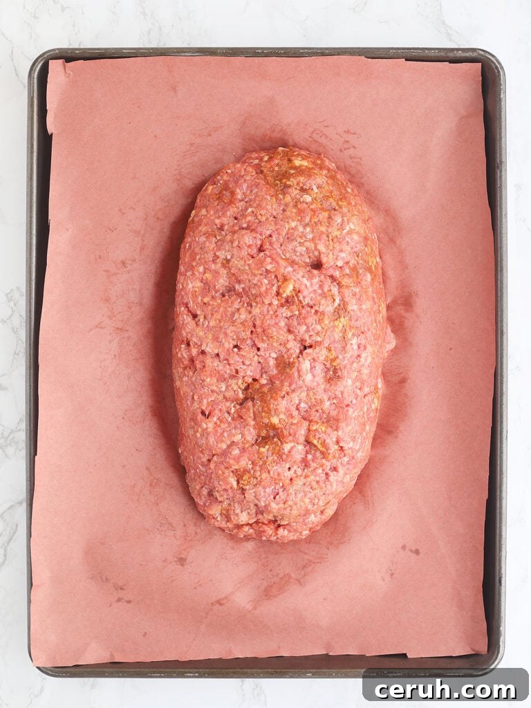 Unbaked meatloaf on a baking sheet.