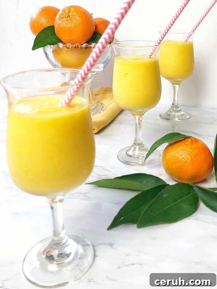 3 glasses filled with orange mango freeze