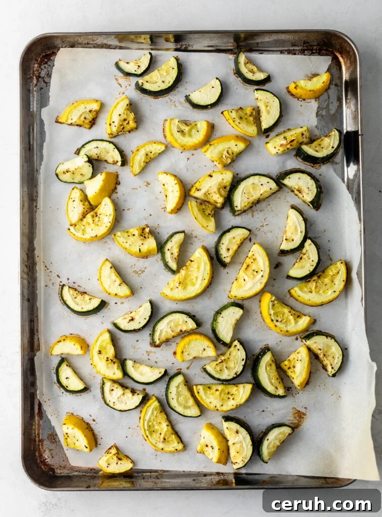 Roasted Zucchini and Summer Squash with Garlic and Parmesan 5 roasted chopped zucchini and squash on a parchment lined sheet pan.