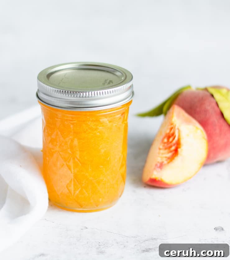 jar of peach jam with peaches next to it