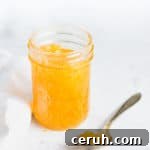 open jar of jam with a spoonful next to it
