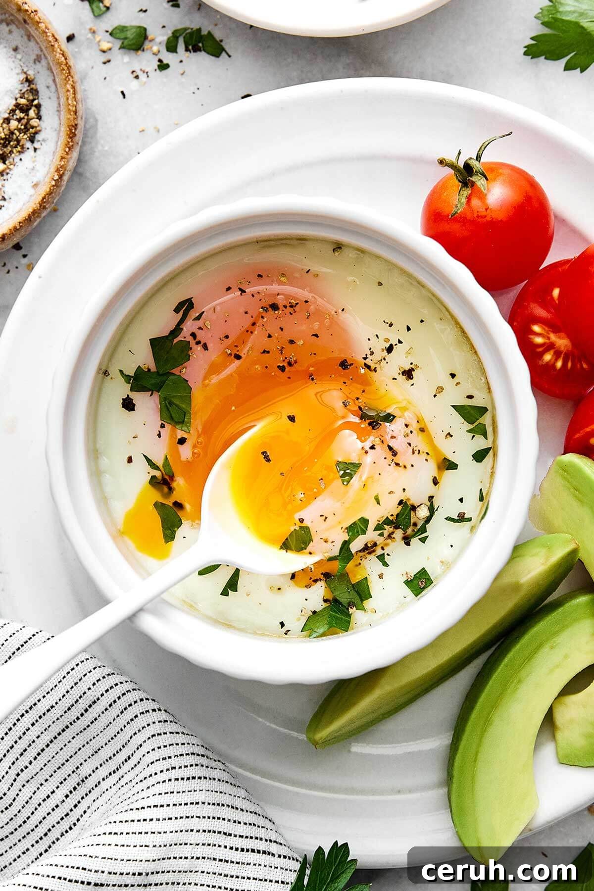 Baked eggs on a plate with tomatoes and avocado is one way to cook eggs.