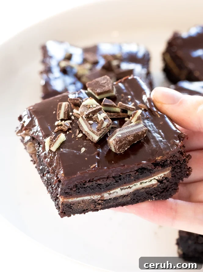 Author holding Chocolate Mint Andes brownies on white serving tray