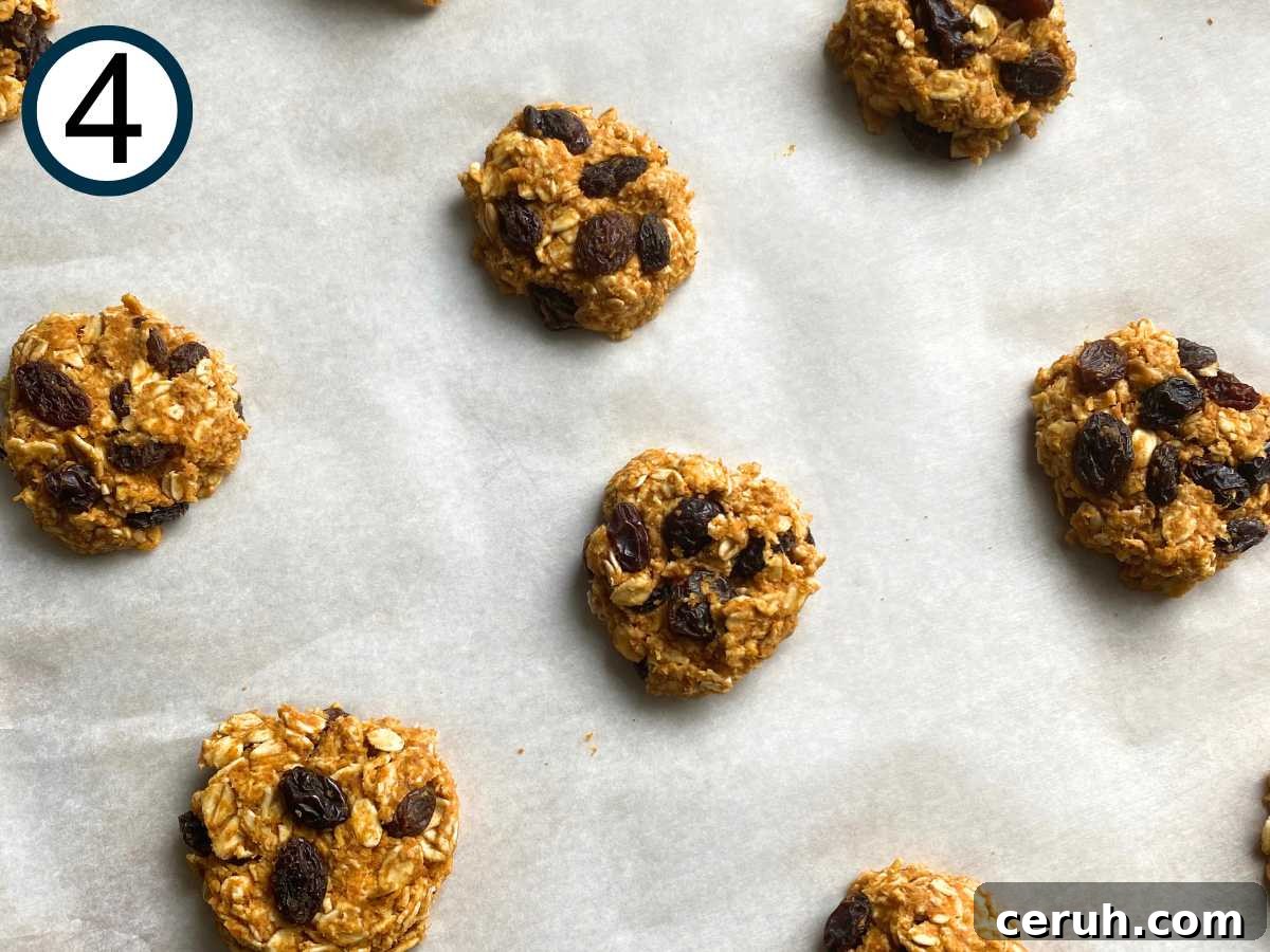Cooked Banana Oatmeal Raisin Cookies on a parchment lined baking sheet.