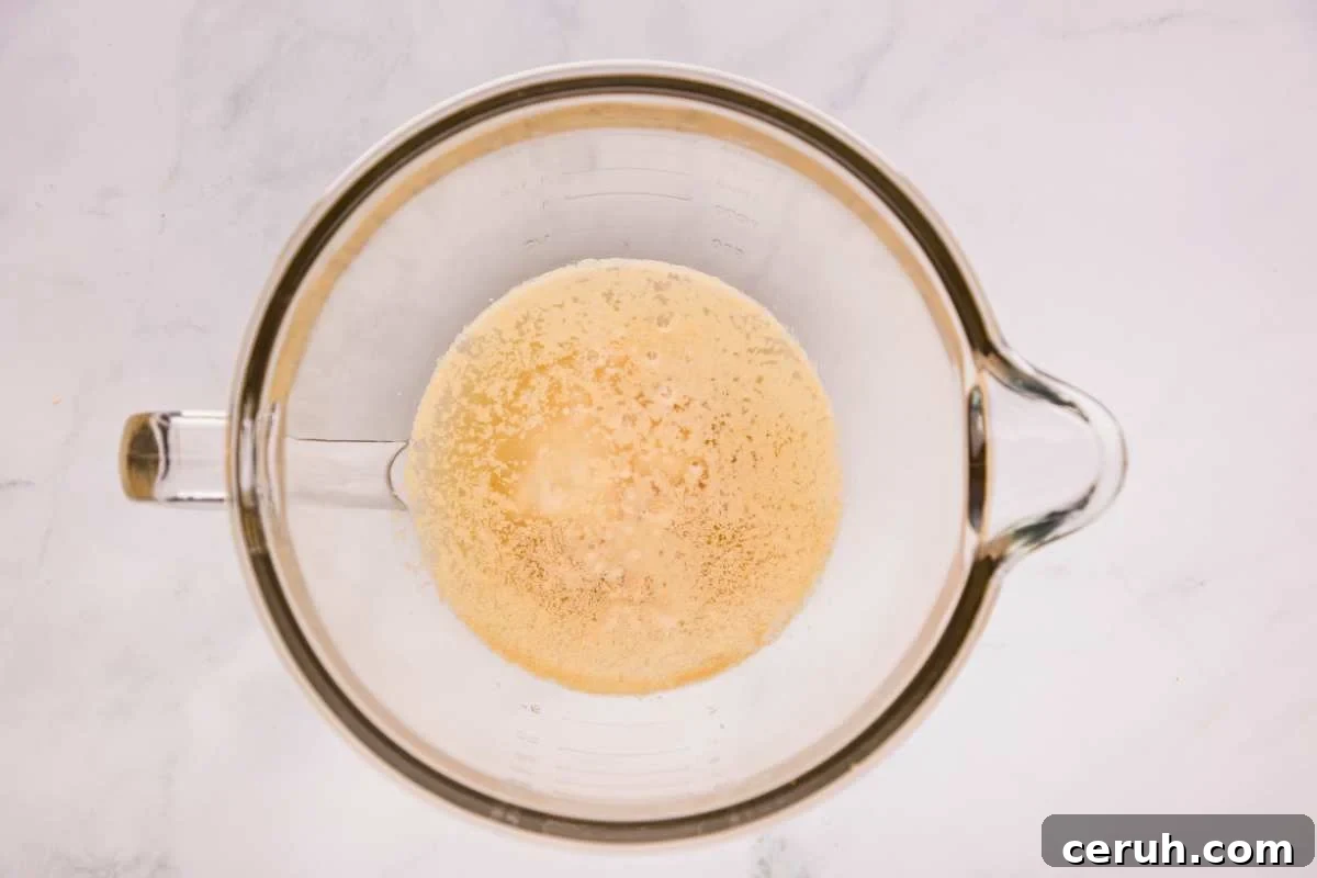sourdough starter, water, sugar, salt, and yeast in mixing bowl.
