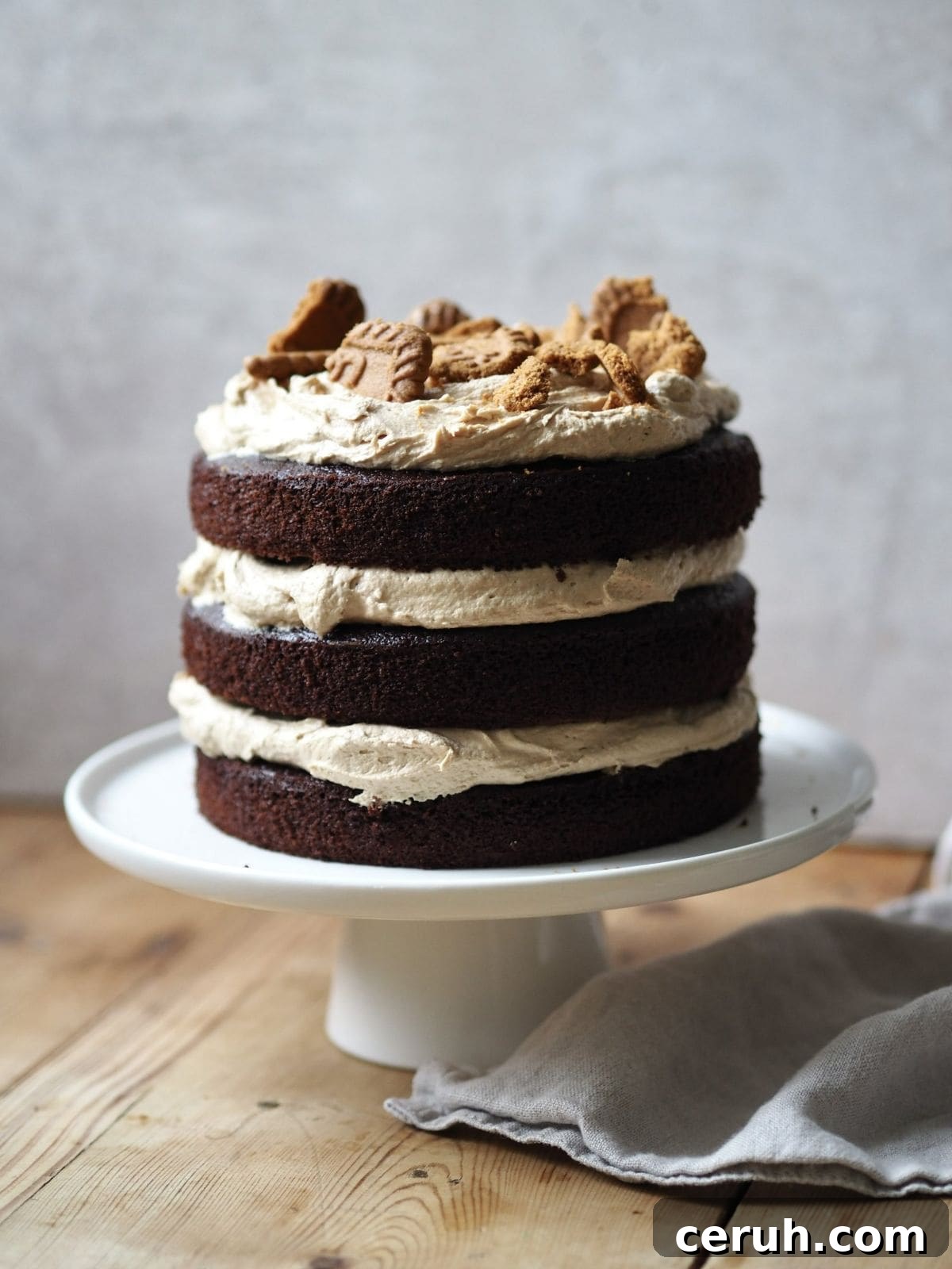 whole biscoff cake on a white cake stand.