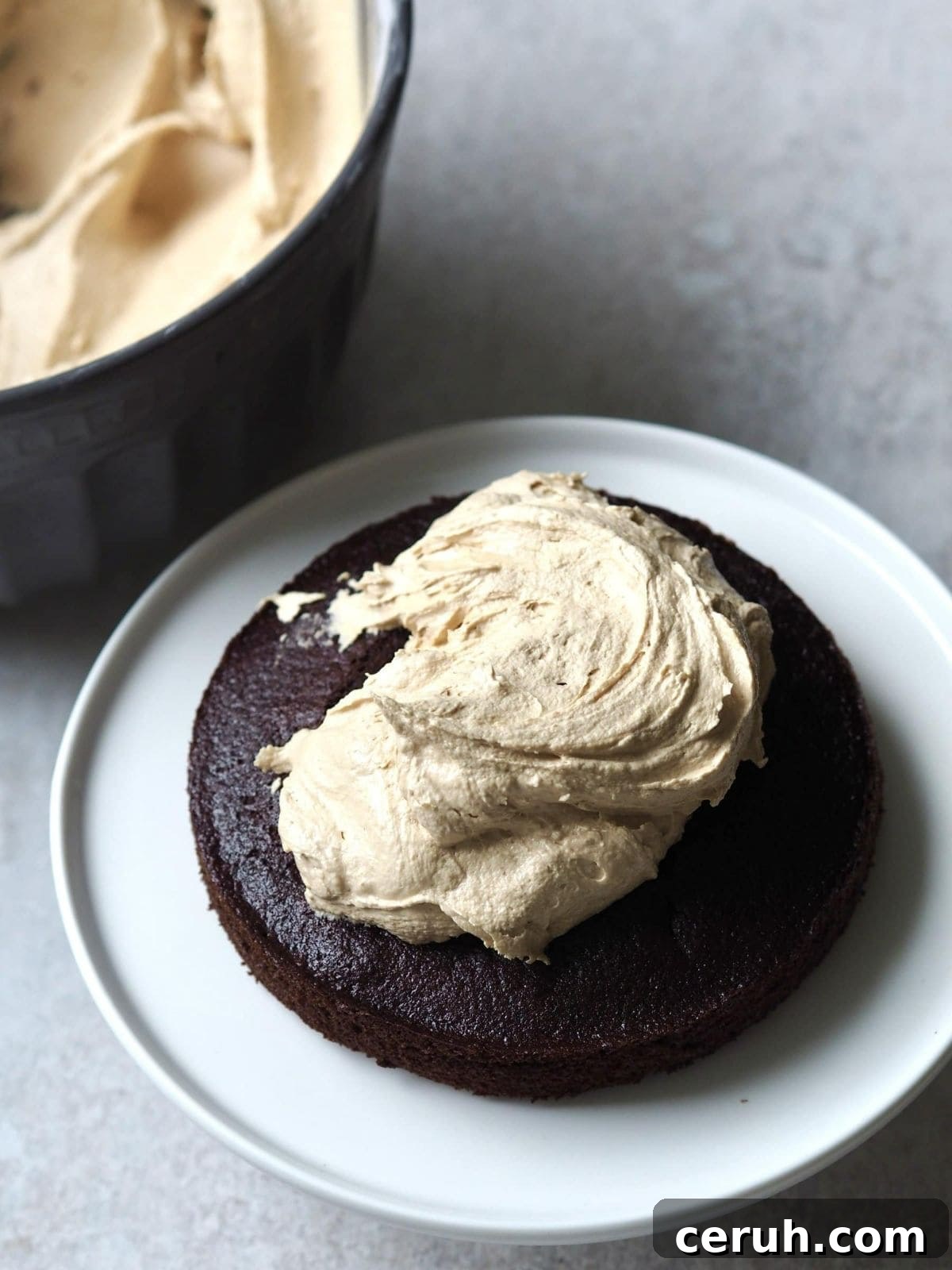 adding biscoff buttercream to the chocolate cake.
