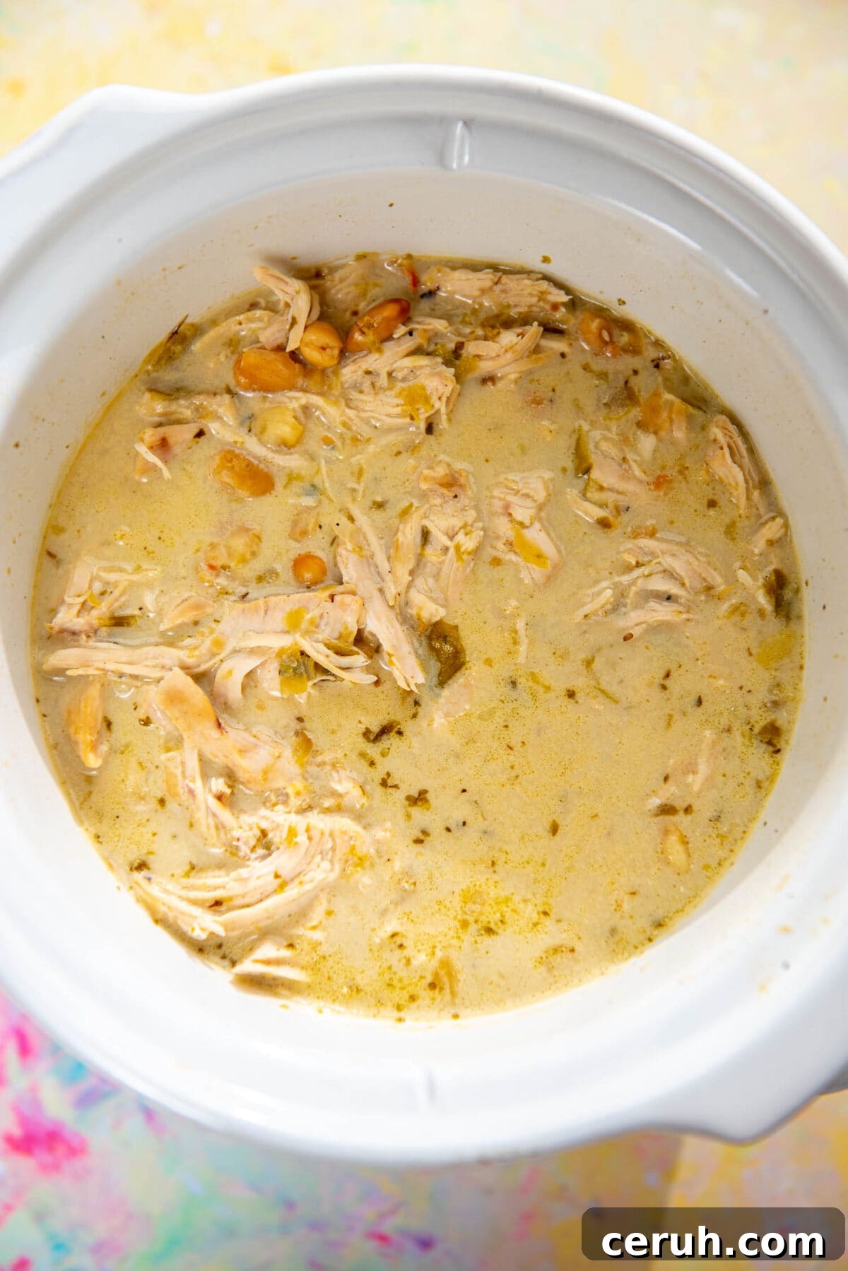 round white slow cooker filled with creamy white chicken chili