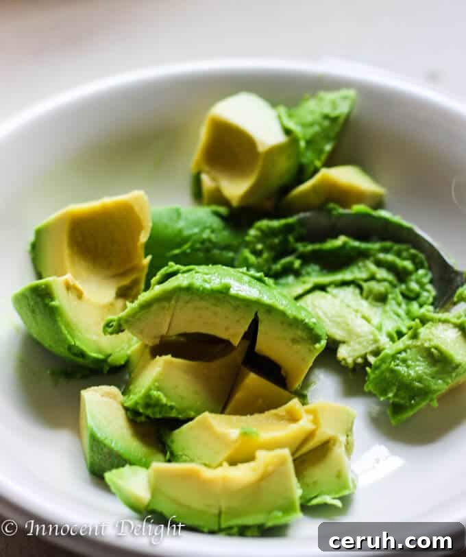 Mixing smashed avocado with feta
