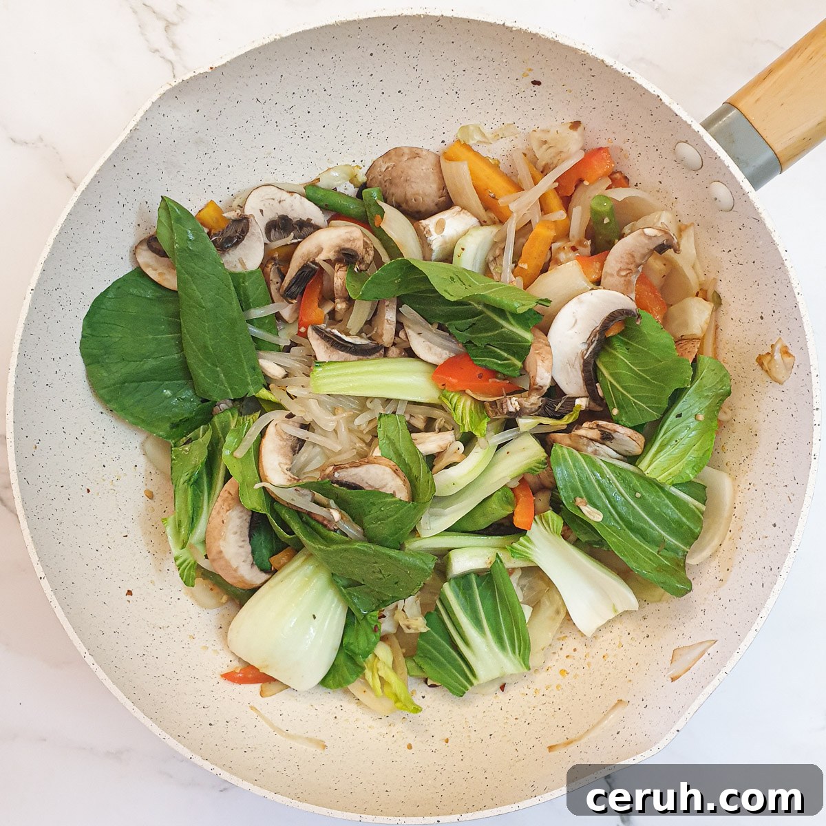Pakchoi, mushrooms and beansprouts added to the frying pan.