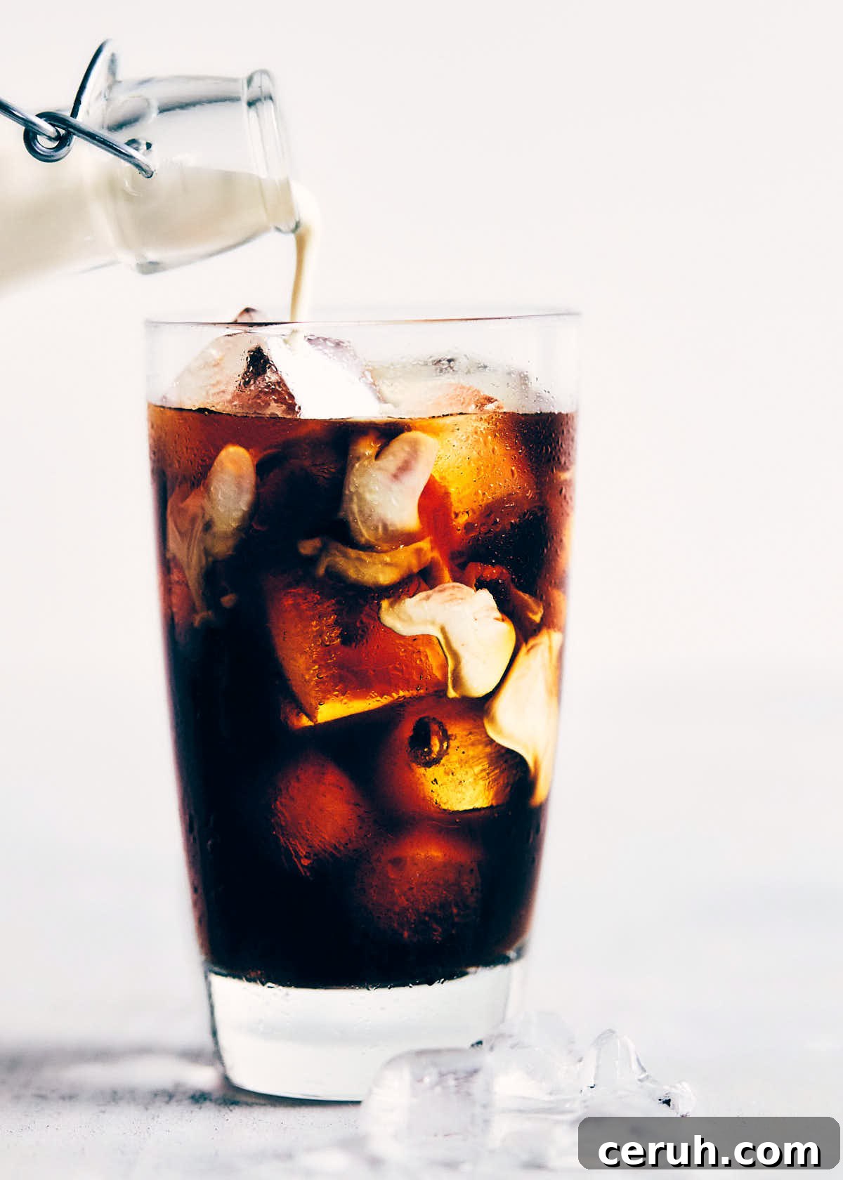 Milk being added into cold brewed coffee with ice