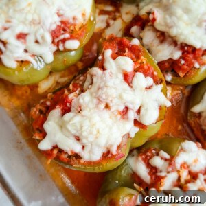 close up of ground beef and rice stuffed green pepper topped with sauce and cheese.