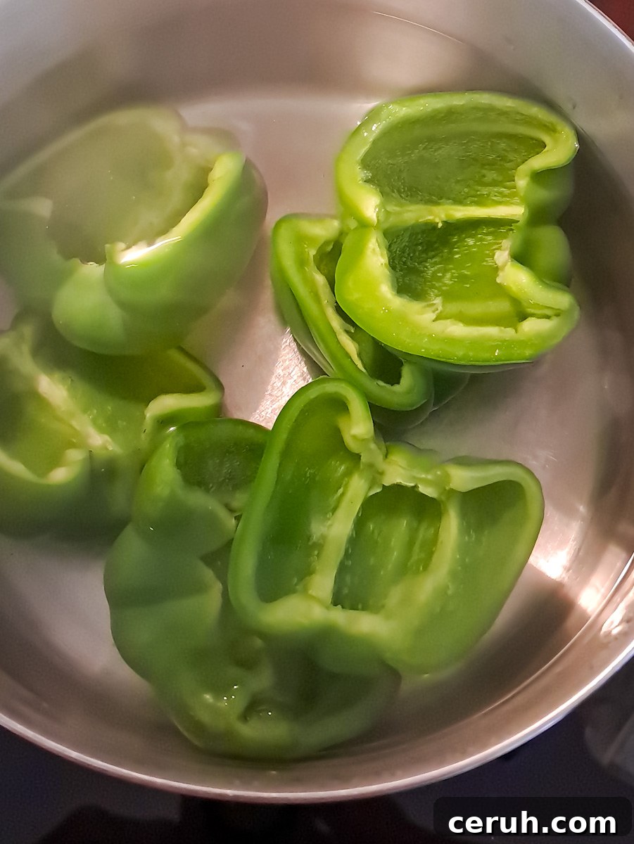 boiling green bell peppers in water to soften.