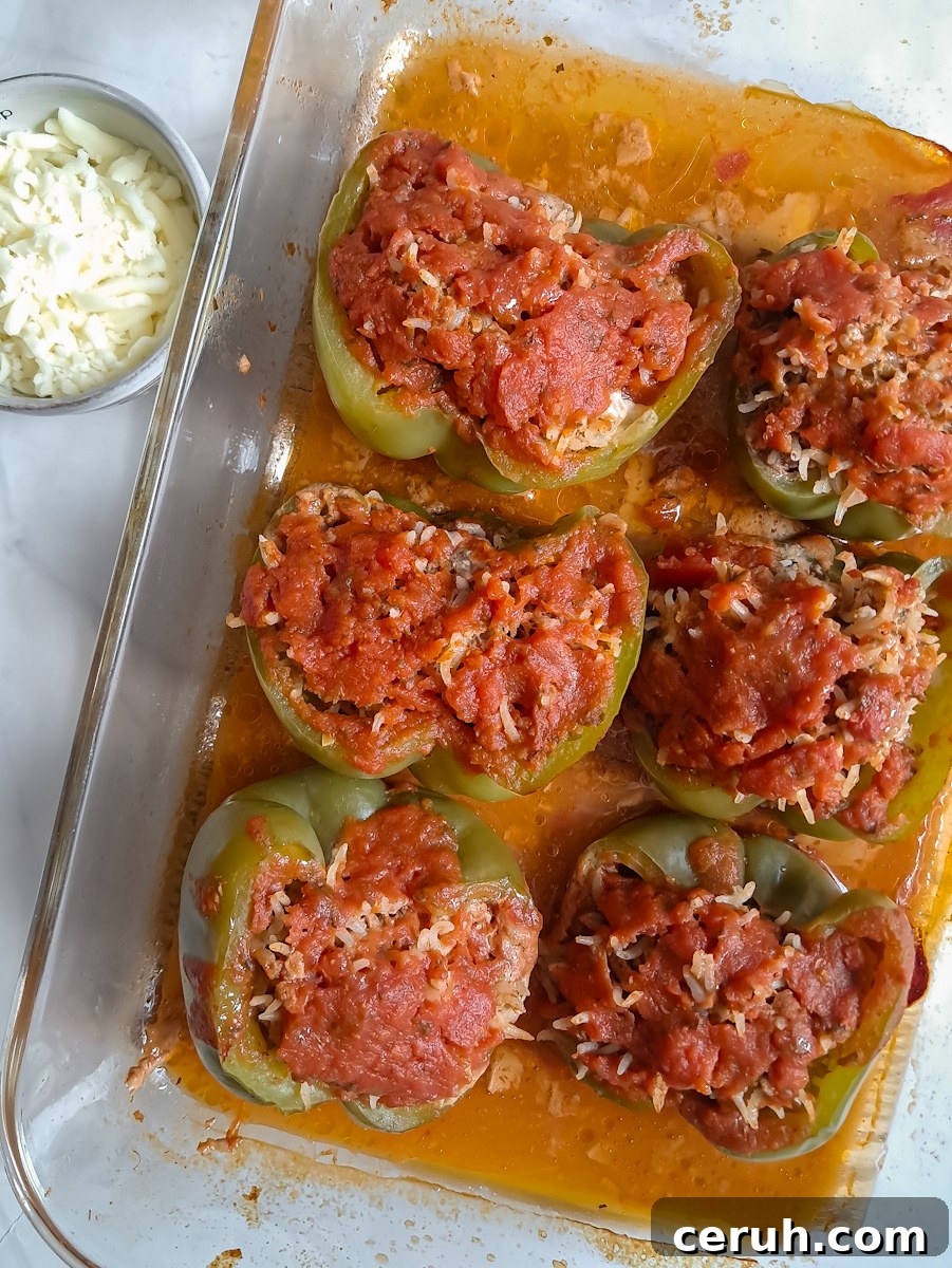 partially baked stuffed peppers ready to spread cheese on top.