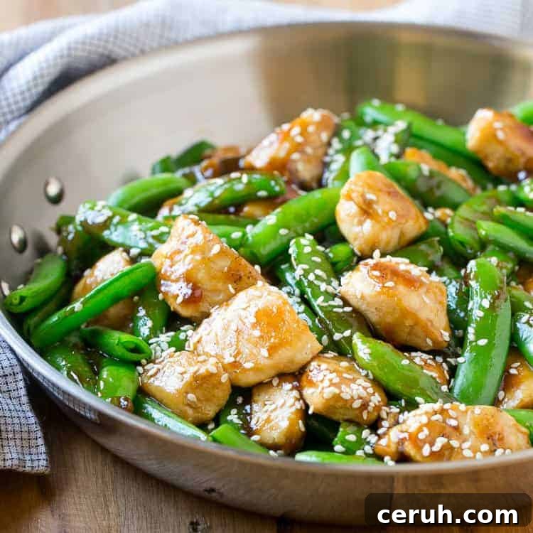 side shot of a pan with sesame chicken and sugar snap peas