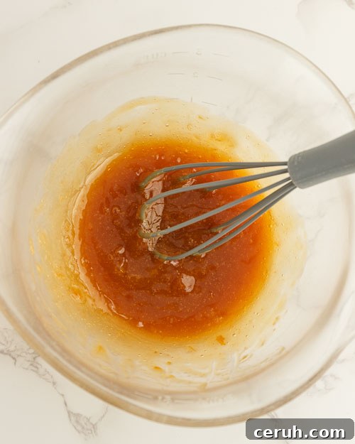 Whisking the apricot glaze in a small bowl.