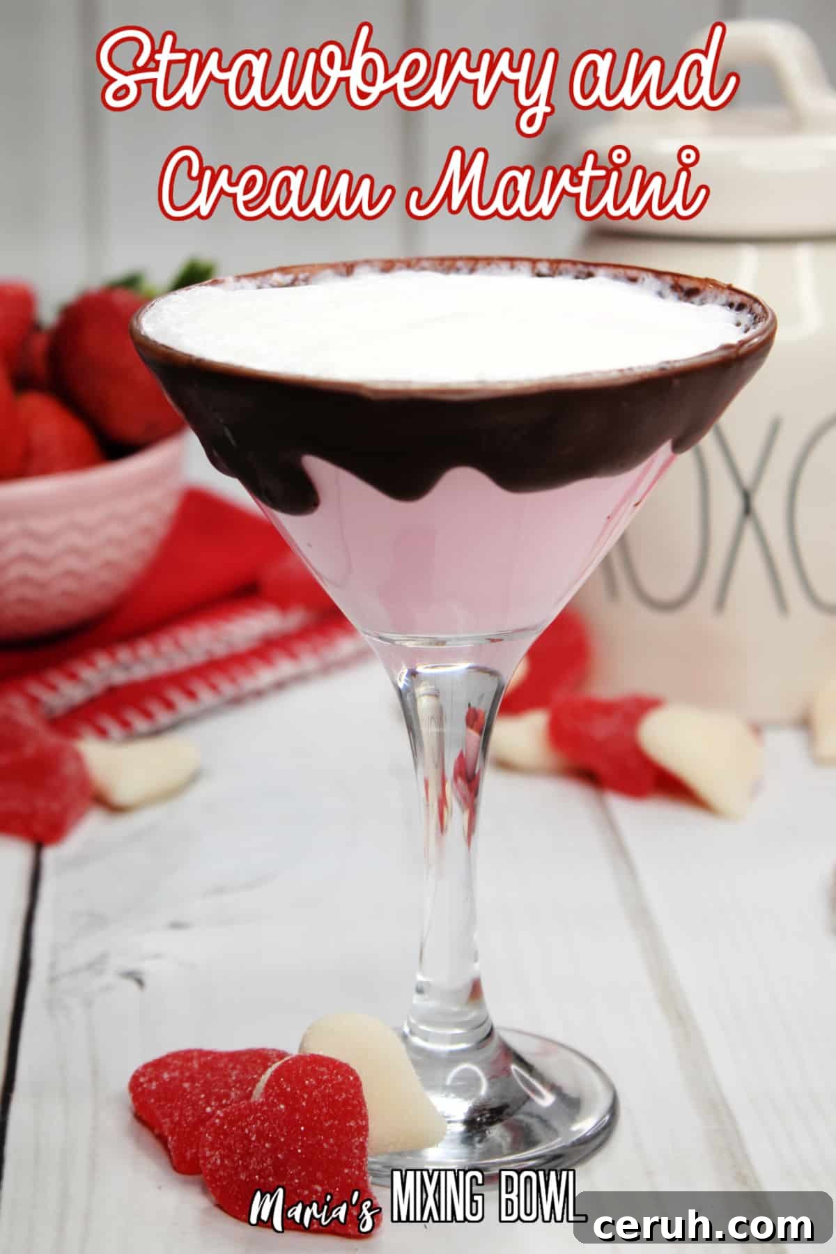 glass of strawberries and cream martini with a bowl of strawberries in the background