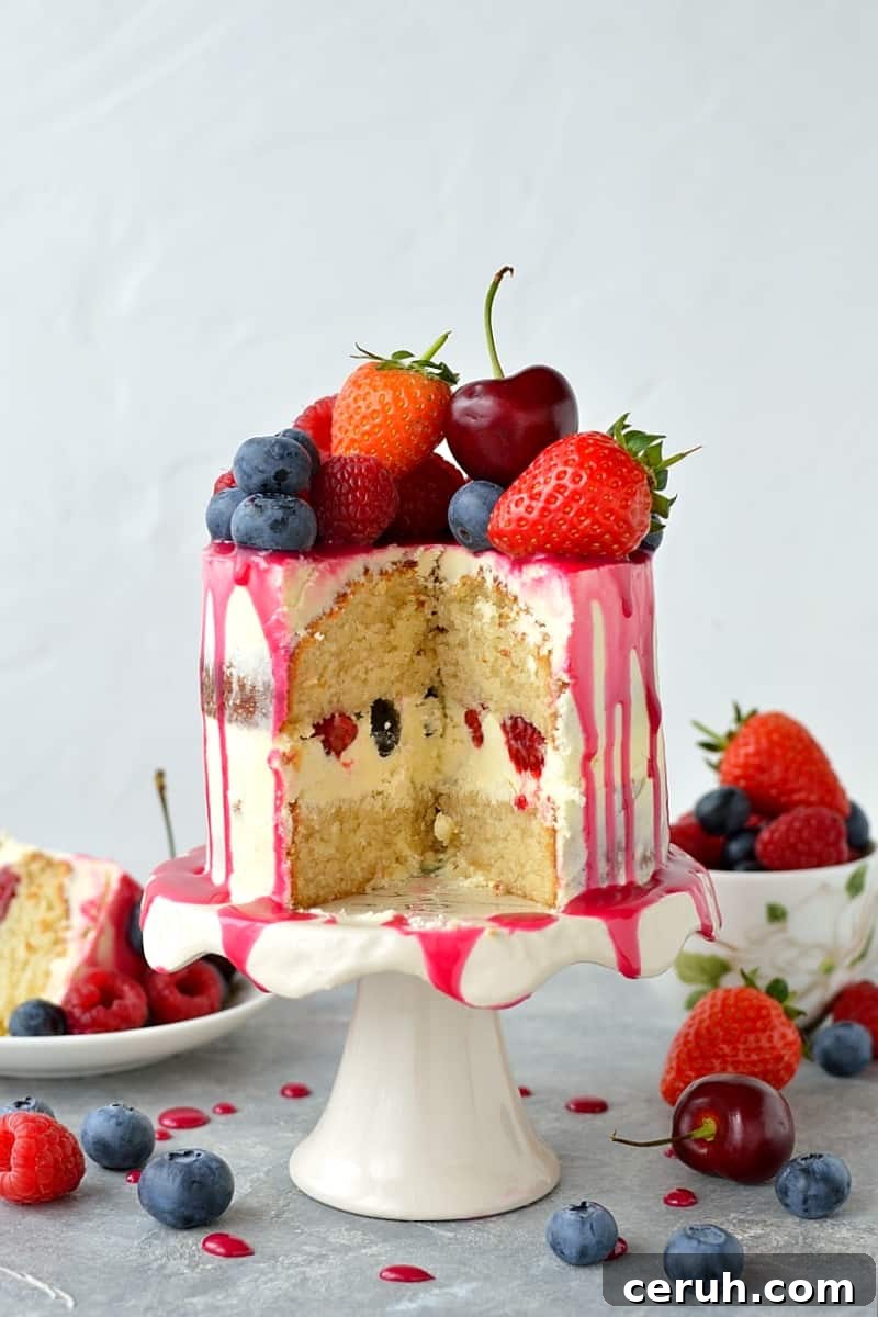 Mini white chocolate berry drip cake - delicious, moist vanilla cake with whipped white chocolate gananche, pink white chocolate drip and fresh berries; serves just 2-4 people!