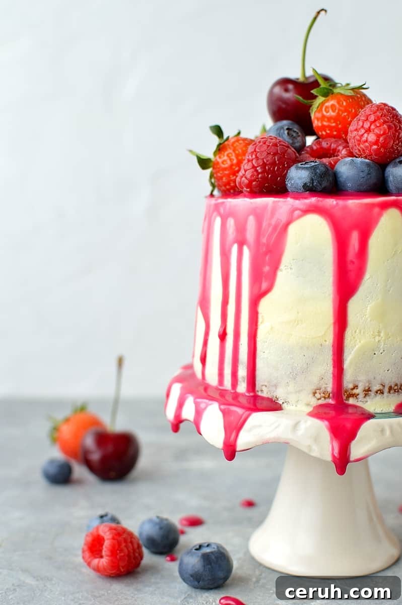 Mini white chocolate berry drip cake - delicious, moist vanilla cake with whipped white chocolate gananche, pink white chocolate drip and fresh berries; serves just 2-4 people!