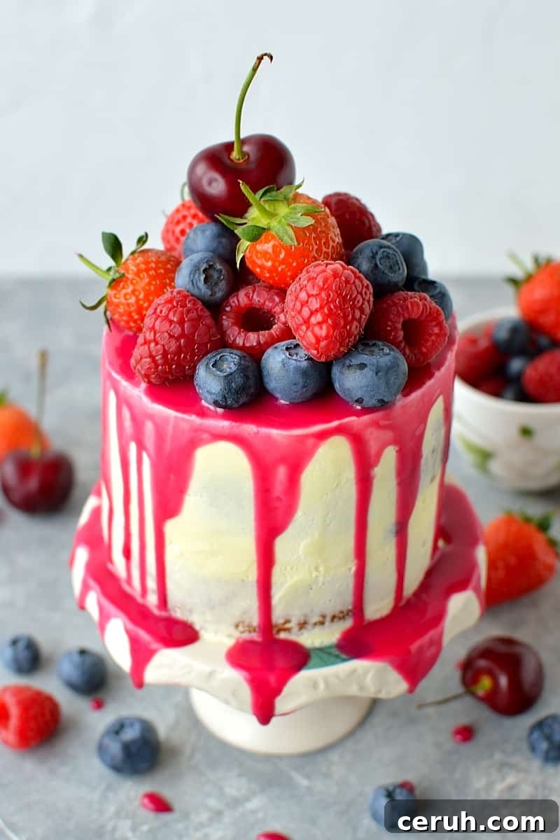 Mini white chocolate berry drip cake - delicious, moist vanilla cake with whipped white chocolate gananche, pink white chocolate drip and fresh berries; serves just 2-4 people!