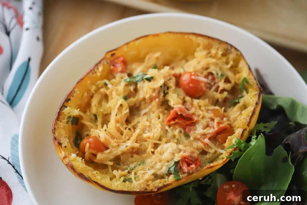 A white plate with half of feta tomato spaghetti squash.